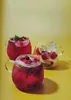 Three glasses of red berry drinks with ice and fruit on a yellow background. Anteprima dell’immagine prodotto