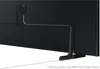 The back of a black television with a stand and a white cable attached. Produktbild-Vorschau