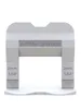 A white tile leveling clip with text on it, shown against a white background. Náhľad obrázku produktu