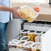 A person is organizing food containers in a kitchen drawer. Náhľad obrázku produktu