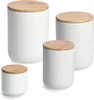 Four white ceramic jars with wooden lids are arranged on a white background. Produktbild-Vorschau