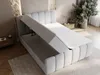 A light gray boxspring bed with its storage compartment open, shown in a bedroom setting with a nightstand and plant. Produktbild-Vorschau