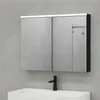 A bathroom medicine cabinet with mirrored doors is mounted on a gray wall above a white sink with a black faucet. Produktbild-Vorschau