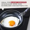 A fried egg is being cooked in a small frying pan on a black induction stovetop. Produktbild-Vorschau