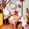 A miniature scene of a whimsical treehouse interior with two bunny figures having a tea party. Podgląd zdjęcia produktu