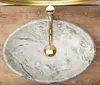 A top-down view of an oval marble sink with a gold faucet. Anteprima dell’immagine prodotto