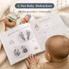 Baby liegt neben aufgeschlagenem Babyalbum mit Hand- und Fußabdruck, Infografik zum Abdruckset Produktbild-Vorschau