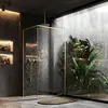 A modern bathroom with a glass shower enclosure, plants, and stone walls. Produktbild-Vorschau