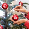 Hands decorating a Christmas tree with red ornaments. Náhled obrázku produktu