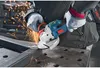 A person is using a Bosch angle grinder to cut metal, creating sparks. Voir les images du produit