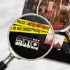 A close-up view of a board game box, with a magnifying glass highlighting police tape and game information. Produktbild-Vorschau