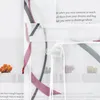 A close-up view of a sheer curtain with a printed pattern of abstract lines and small cactus illustrations. A plastic drawstring holder is visible. Produktbild-Vorschau