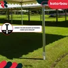 A metal post anchor for a tent or pavilion is shown in a grassy outdoor setting. Náhľad obrázku produktu