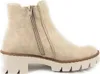 A side view of a beige ankle boot with a thick sole and a zipper. Voir les images du produit