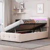 A bed with its storage compartment open, showing the mattress and bedding, in a bedroom setting. Produktbild-Vorschau