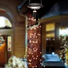 A solar-powered string light decoration hangs from a ceiling, illuminating a porch or patio area. Voir les images du produit