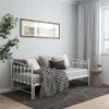 A daybed with pillows and a blanket in a room with a window and curtains. Produktbild-Vorschau