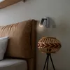 A bedside scene with a headboard, a lamp, and a decorative basket. Náhľad obrázku produktu