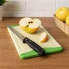 A cutting board with a knife and apples on a wooden counter. Produktbild-Vorschau