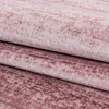 A close-up view of a folded pink rug with a textured, abstract pattern. Podgląd zdjęcia produktu