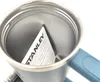 Close-up view inside a blue Stanley Quencher H2.0 Flowstate tumbler, showing a folded instruction manual with the 'STANLEY' logo visible. Produktbild-Vorschau