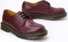 A pair of burgundy leather shoes with black laces and yellow stitching on a white background. Produktbild-Vorschau