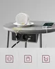 A round table with a spilled cup of coffee and a charging phone, featuring an integrated power strip with outlets and USB ports. Náhled obrázku produktu
