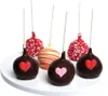 A white plate with six cake pops decorated for Valentine's Day. Produktbild-Vorschau