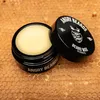 A jar of beard wax is shown open, with the lid placed next to it, on a honeycomb background. Produktbild-Vorschau