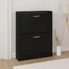 A black shoe cabinet with two drawers is shown in a room with a floor lamp and a vase. Podgląd zdjęcia produktu