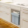 A built-in kitchen trash and recycling system with a pull-out drawer and a basket on top. Voir les images du produit