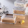 A set of clear plastic food storage containers filled with different types of pasta, stacked on a wooden surface. Two lemons are placed in the foreground. Produktbild-Vorschau