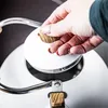 A hand is shown placing the lid on a kettle. Podgląd zdjęcia produktu