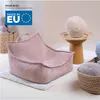 A pink corduroy beanbag chair is placed on a white rug, with baskets of yarn and a decorative stool with a round cushion in the background. Anteprima dell’immagine prodotto