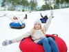 People tubing down a snowy hill. Produktbild-Vorschau