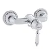 A chrome and white shower faucet with decorative detailing. Produktbild-Vorschau
