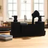 A black soap dispenser set with a sponge holder and brush, placed on a wooden table in a kitchen setting. Produktbild-Vorschau