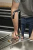A person is installing a faucet in a sink. Produktbild-Vorschau