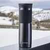 A black Contigo travel mug sits on a railing with a snowy landscape in the background. Anteprima dell’immagine prodotto