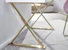 Close-up of the golden metal legs of a white desk on a light gray patterned rug. Anteprima dell’immagine prodotto