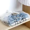 Vacuum-sealed storage bags containing folded clothes on a wooden shelf. Anteprima dell’immagine prodotto