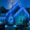A house decorated with blue icicle lights at night. Produktbild-Vorschau