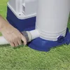 A hand is shown connecting a hose to a pool filter pump unit, which is sitting on a grassy lawn. Voir les images du produit