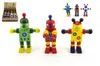 A display of wooden toy robots, with a box of smaller robots in the background. Voir les images du produit
