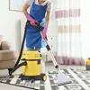 A person is using a carpet cleaner in a room with a rug and furniture. Produktbild-Vorschau