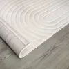 A close-up, angled view of a rolled-up rug on a wooden floor. Anteprima dell’immagine prodotto