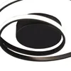 A close-up view of a modern black ceiling light with a swirling design and integrated LED lighting. Voir les images du produit
