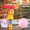 A child in a yellow raincoat holding a red umbrella stands next to a pink unicorn suitcase in the rain. Produktbild-Vorschau