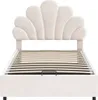 A beige upholstered bed frame with a scalloped headboard and wooden slats for mattress support, shown against a white background. Produktbild-Vorschau