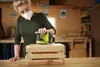 A woman is sanding a wooden crate in a workshop. Podgląd zdjęcia produktu